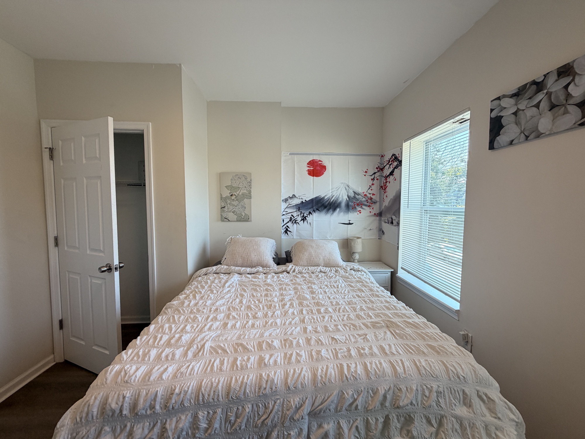 A made bed under twin windows in suite 201 at Edo.