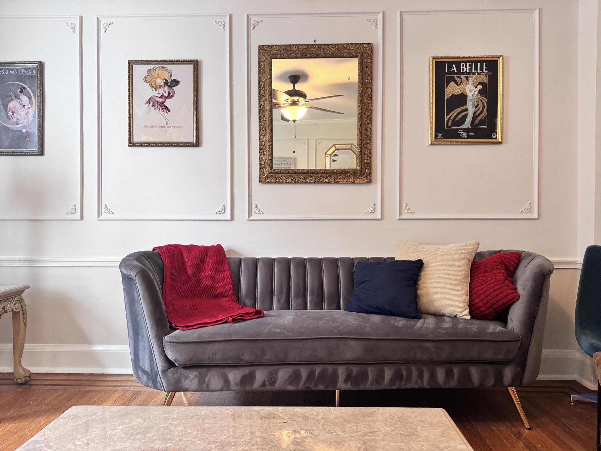 Blue velvet sofa and framed prints in the Lutetia living room