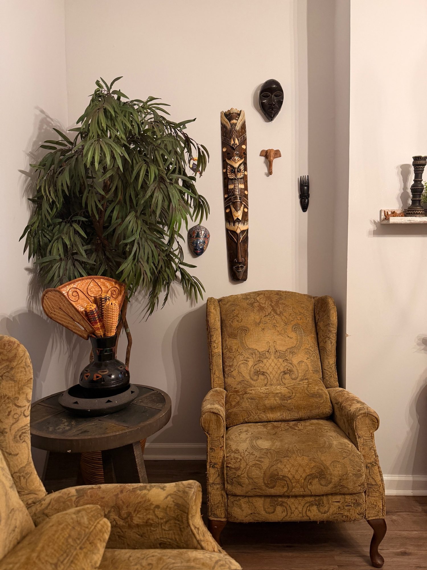 Carved masks on the wall and a wingback chair in the Ujamaa living room