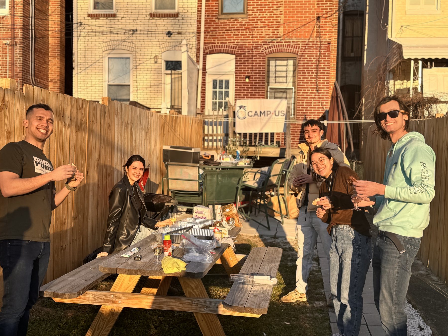 Residents around the picnic table in a CAMP-US backyard