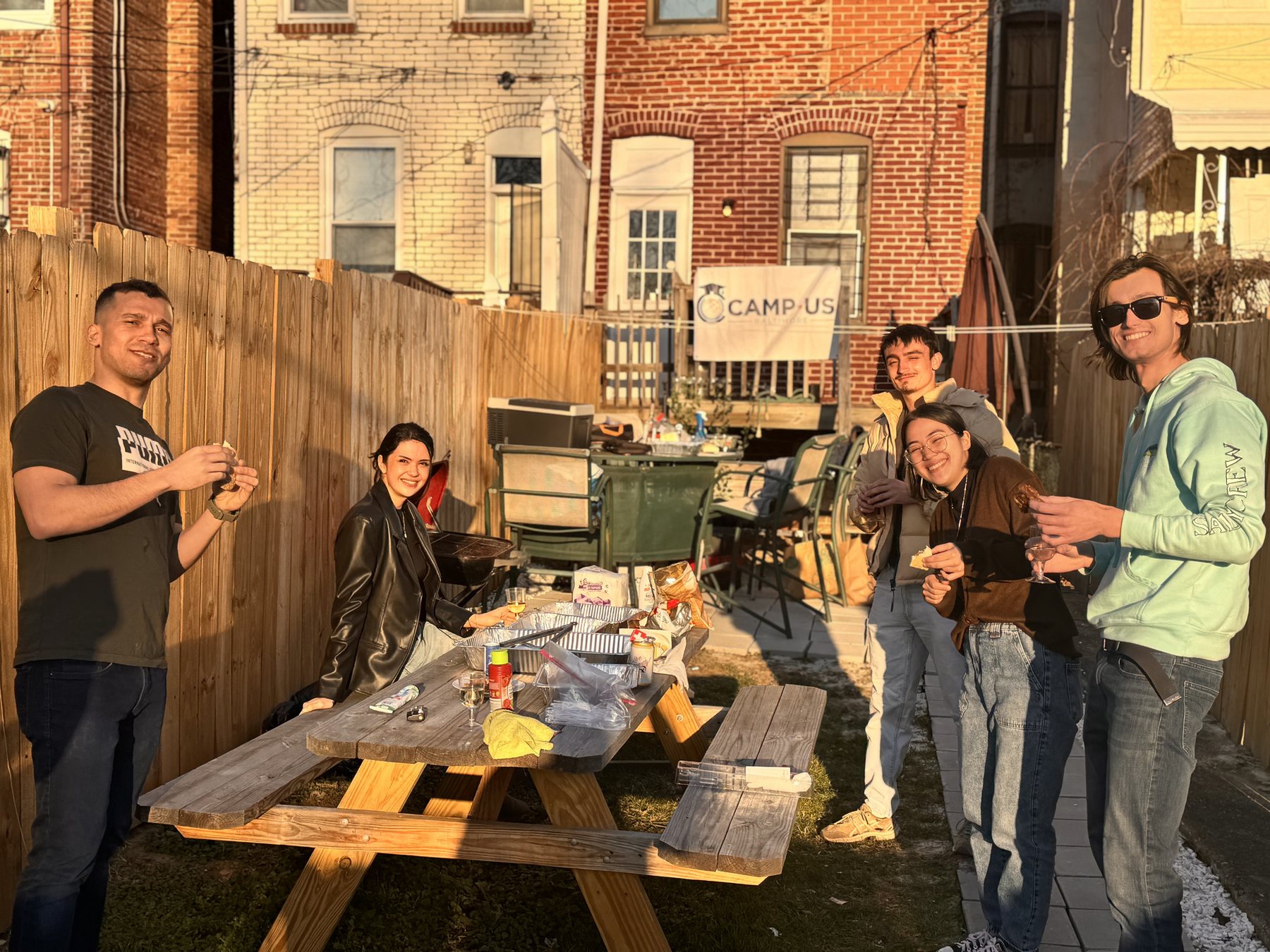 Residents at the table in a CAMP-US backyard