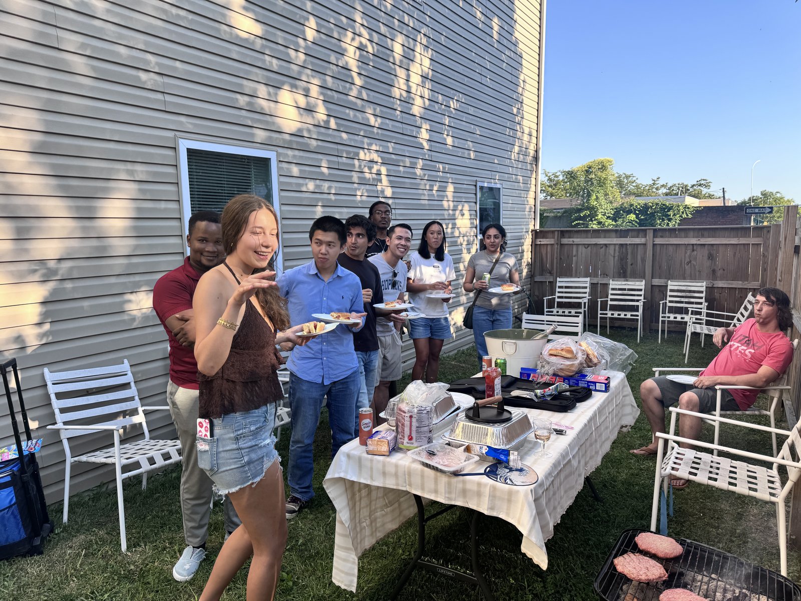 CAMP-US residents being served at the table in the backyard
